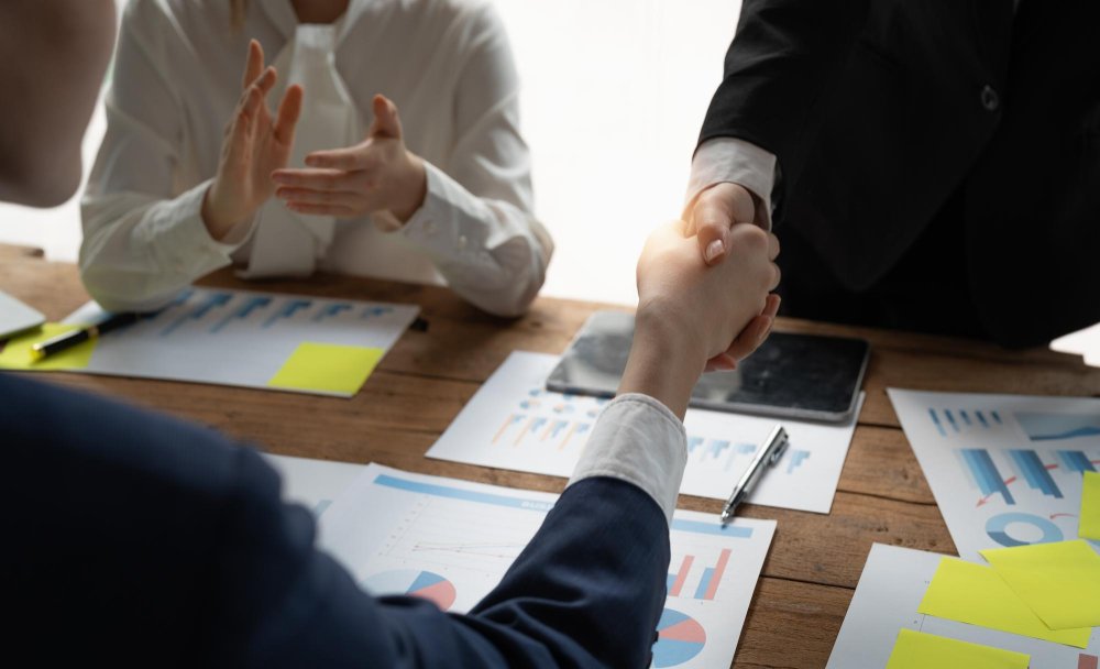 https://www.robbinex.com/wp-content/uploads/2023/11/business-people-shaking-hands-finishing-up-meeting-business-etiquette-congratulation-merger-acquisition-concept.jpg